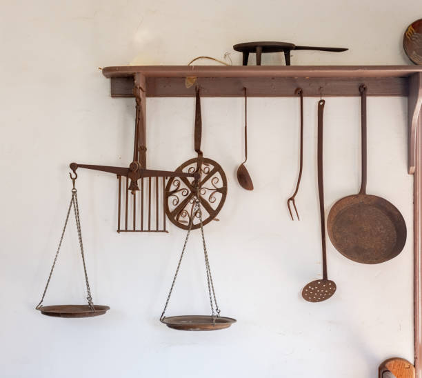istock Old rusted kitchen utensils hanging on a rack 1357318211