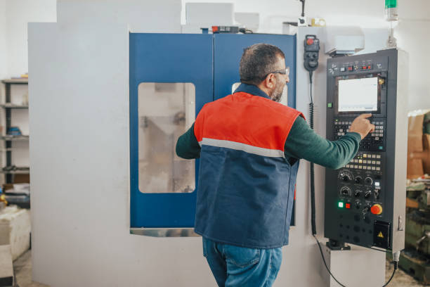 leitender mann, der an der cnc-maschine arbeitet - mechanician stock-fotos und bilder