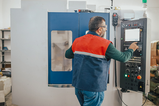 senior man working on cnc machine