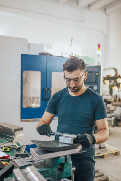 istock Young man working on cnc machine. young entrepreneur quality inspection during machining 1357319811