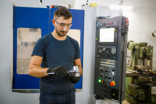istock Young man working on cnc machine. young entrepreneur quality inspection during machining 1357320705