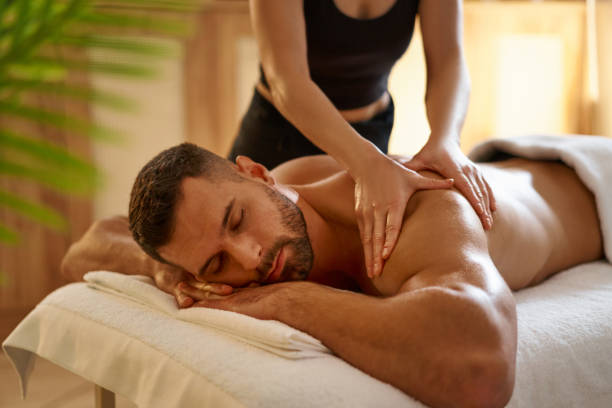 Young man having a massage by a professional masseuse stock photo