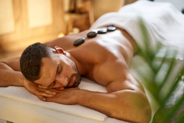 istock Relaxed man enjoying hot stones massage 1357320758