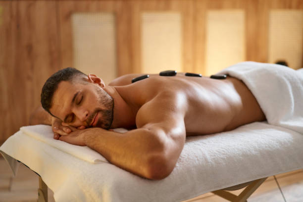 man enjoying hot stones massage - lastone therapy spa treatment health spa massaging imagens e fotografias de stock