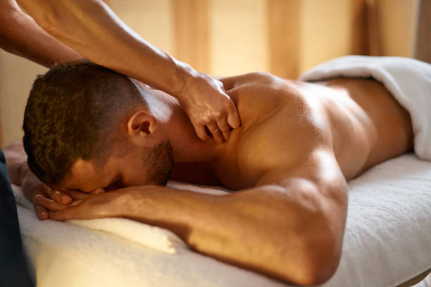 istock Young man getting his back massaged by a professional masseuse 1357320919