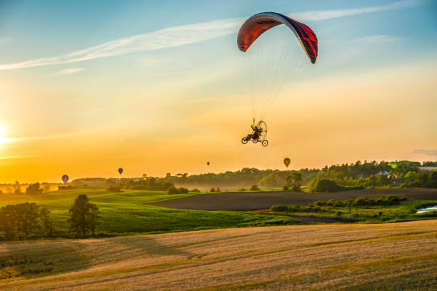 istock Powered paragliding over the countryside 1357320971