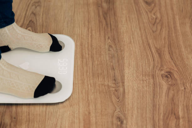 istock Girl Measures Weight on Smart Scales. Modern Electronic Device 1357321001