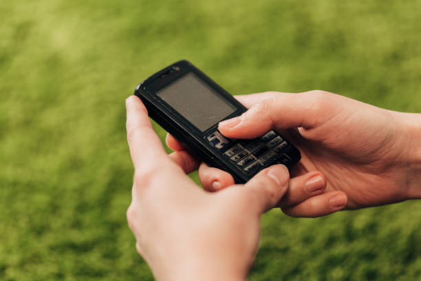 istock Girl Holds An Old Button Phone In Her Hand 1357321737