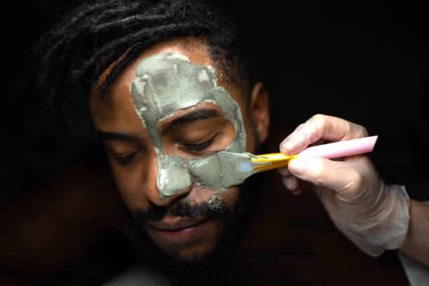 hombre adulto medio haciendo un tratamiento facial en un spa - mud wellbeing spa treatment beautician fotografías e imágenes de stock