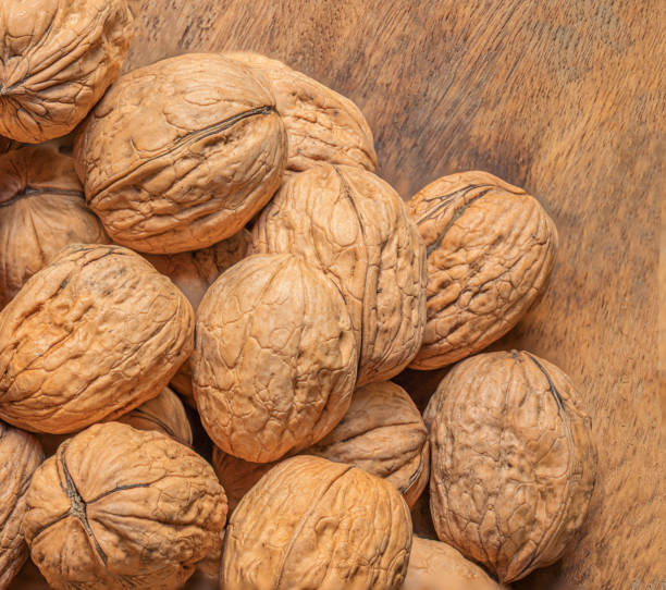 istock Walnuts on dark vintage table. Walnuts kernels with green leaves. Copyspace. 1357322148
