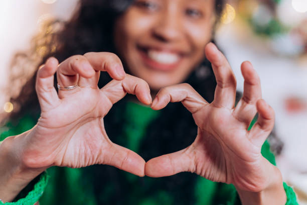 istock Mother and daughter pose showing hearts with fingers 1357325419