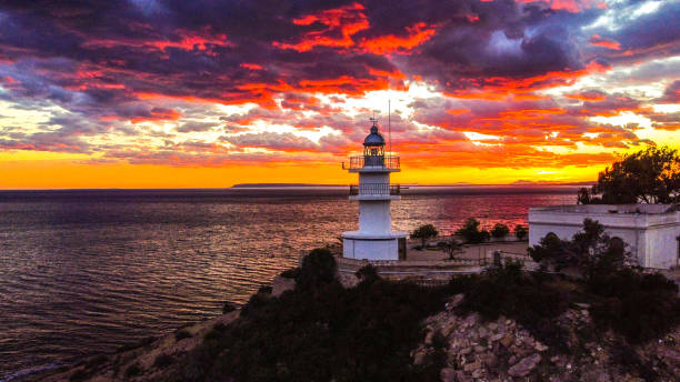 istock Lighthouse with the sunset sun behind 1357325489