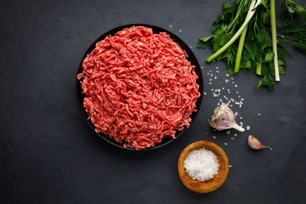 istock Minced meat, spices and herbs on black background. 1357326345