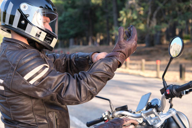 un motociclista indossa i guanti prima di andare in moto - helmet motorized sport biker crash helmet foto e immagini stock