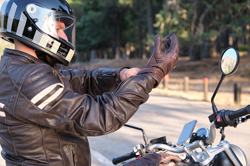 A biker puts on gloves before riding on motorbike