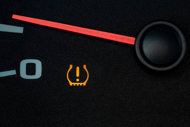 Car low tire pressure warning light. Vehicle repair, maintenance, and cold weather safety concept. stock photo