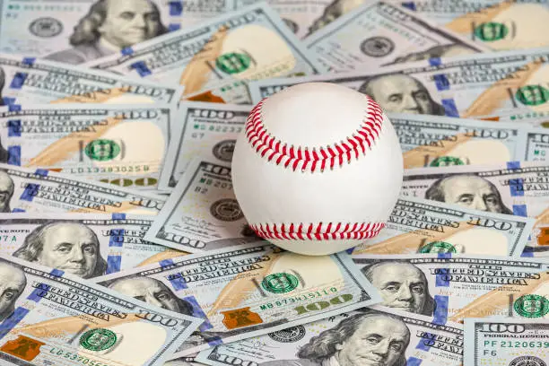 Photo of Baseball with cash money. Major league strike, lockout and sports betting concept.