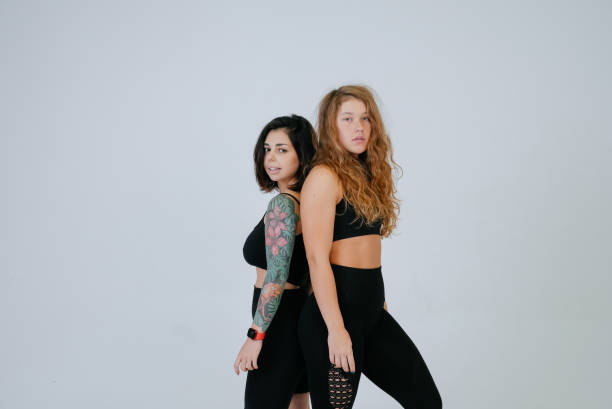 istock Two young women posing over white background. 1357327722