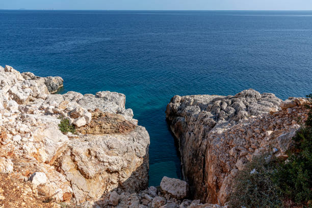 istock Small rocky cove in the blue sea 1357329284