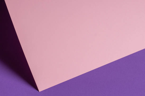istock Blank pastel pink paper sheet card note with shadows on violet purple background. Abstract geometric monochrome pink background with copy space for text. Front view 1357334423