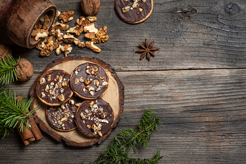Homemade chocolate biscuits with walnuts on a wooden board and a rustic wooden background. Stock photo