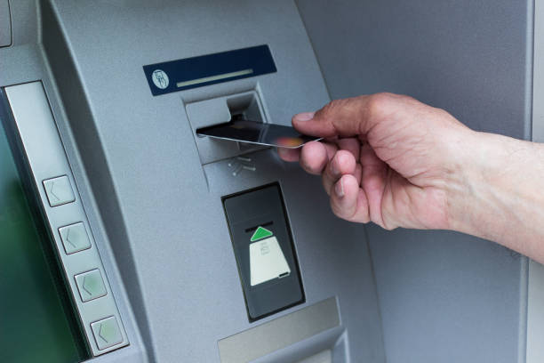 istock Hand of a senior man using a ATM 1357339174