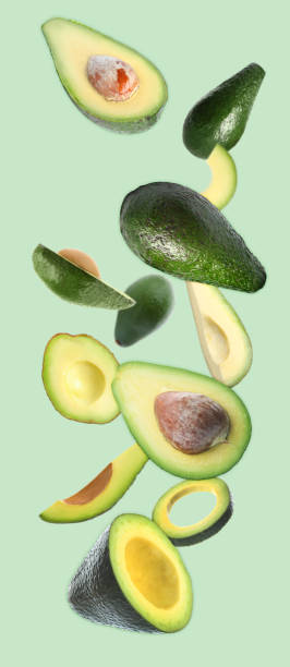 istock Fresh ripe avocados falling on light blue background 1357341927
