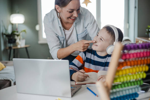 istock Caring mother helps her son to study at home 1357343562