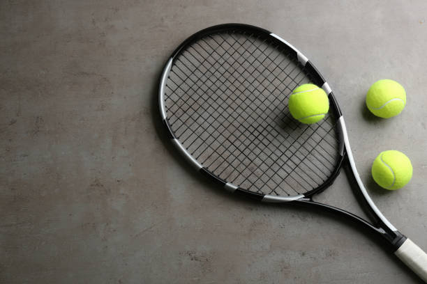 istock Tennis racket and balls on grey table, flat lay. Space for text 1357343590