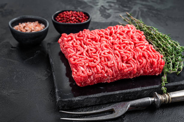 istock Fresh Raw Mince Ground beef meat with thyme. Black background. Top view 1357343689