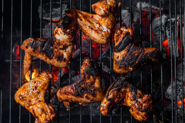 istock Chicken wings on barbecue, outdoor BBQ grill with fire. Top view 1357343782