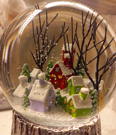 A winter scenario of snowy houses inside a snow crystal ball