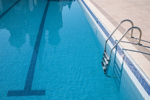 Empty swimming pool view with a steel ladder. Antalya, Turkey.