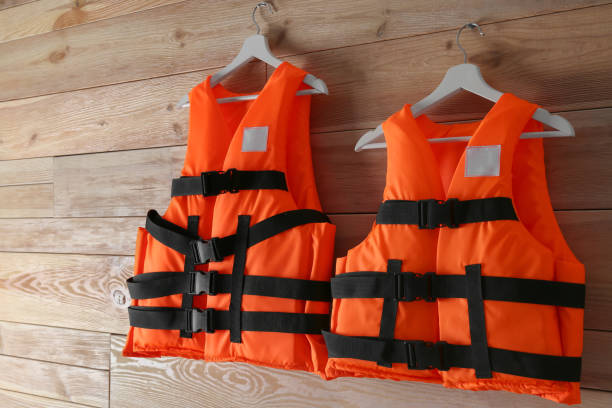 istock Orange life jackets on wooden background. Personal flotation device 1357345127