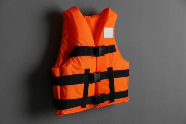 istock Orange life jacket on grey background. Personal flotation device 1357345128