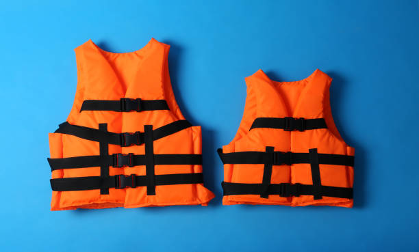 istock Orange life jackets on blue background. Personal flotation device 1357345755
