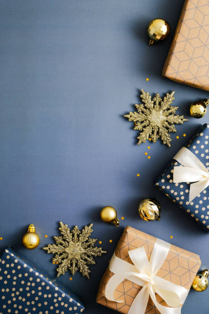 istock Christmas vertical blue background, xmas poster, social media stories banner design. Flat lay Christmas gift boxes and golden decorations on blue background. Top view, copy space. 1357347321