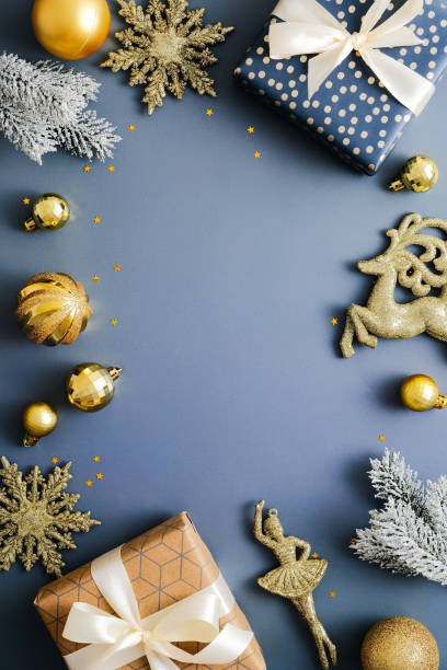 istock Christmas vertical blue background, xmas poster, social media stories banner design. Christmas gift boxes, gold bauble and decorations on blue table. Flat lay, top view, copy space. 1357347325