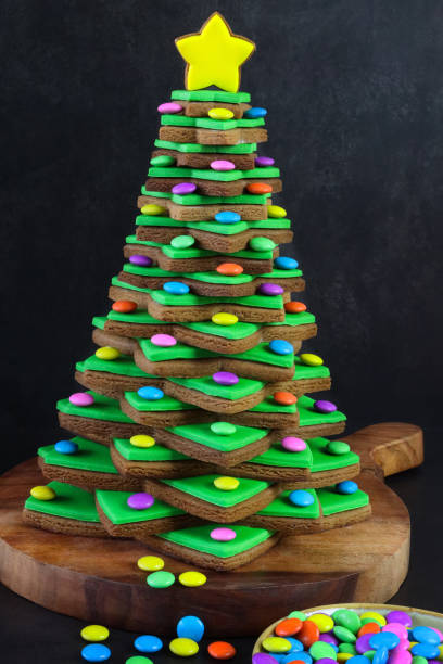 緑のフォンダンアイシングと積み重ねられたジンジャーブレッドスタークッキーのクローズアップ画像クリスマスツリーは、黄色のアイススタービスケットをトッピングしたマルチカラーの� - star shape christmas ornament heap stack ストックフォトと画像