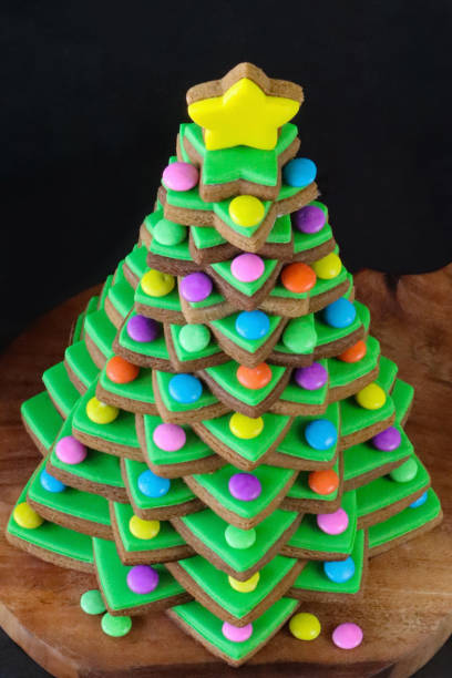 緑のロイヤルアイシングでアイスされた積み重ねられたジンジャーブレッドスタークッキーから形成されたフルフレーム画像クリスマスツリーは、黄色のアイススタービスケットをトッピン� - star shape christmas ornament heap stack ストックフォトと画像