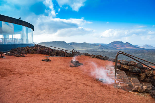 vapor procedente del volcán utilizado para cocinar en el parque nacional de timanfaya en lanzarote, islas canarias, españa. paisaje volcánico cubierto de piedras de lava roja y ceniza - parque nacional de timanfaya fotografías e imágenes de stock