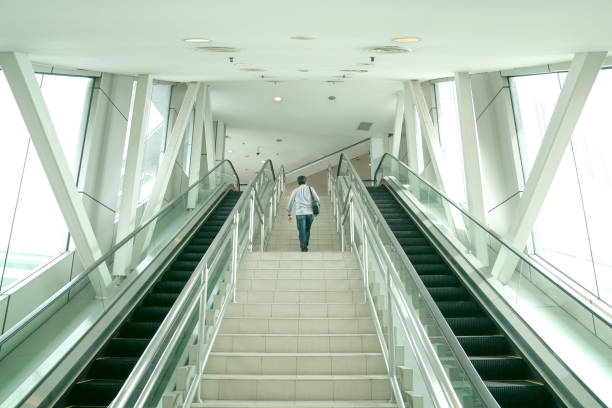 istock Man going up the stairs inside a modern building 1357355026