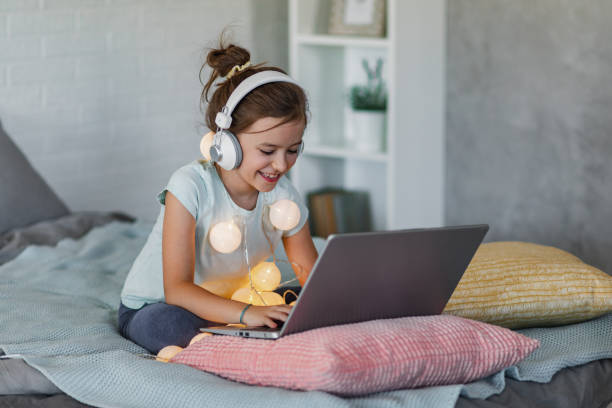 istock Young girl in bed, using laptop during Holidays 1357356845