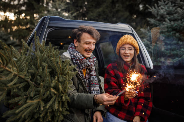 istock Young couple with sparklers and new Christmas tree 1357360494