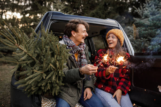 istock Young couple with sparklers and new Christmas tree 1357360496
