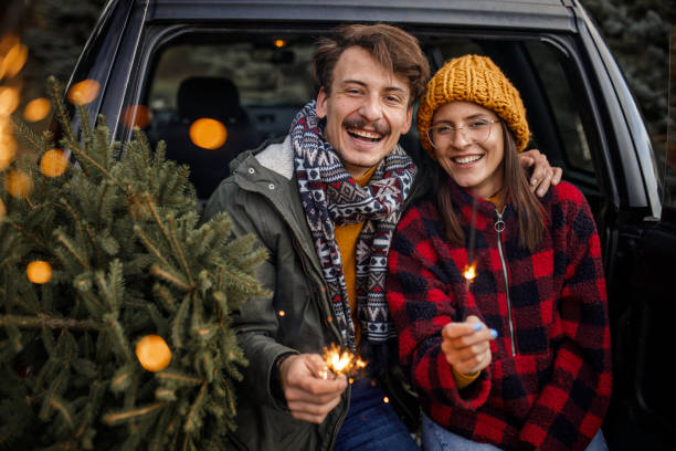 istock Young couple with sparklers and new Christmas tree 1357360506