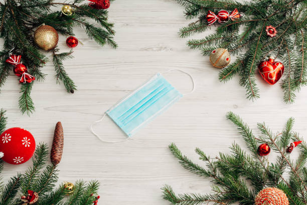 istock Christmas Composition with Mask on a White Wooden Table with Copy Space 1357364978