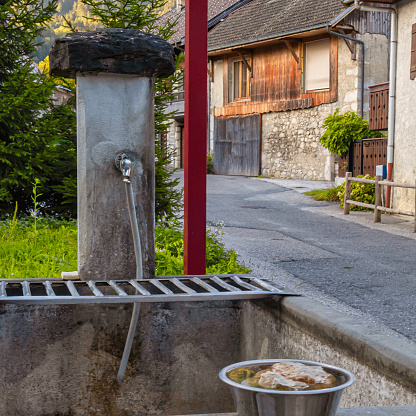 Alex, France - September 12 2020 : an historic communal street water well and pump to clean in a small alpine french village