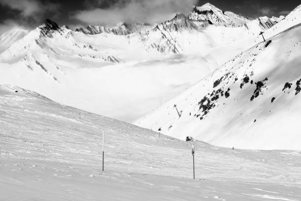 istock Black and white snowy freeride trace and mountains in clouds 1357365113