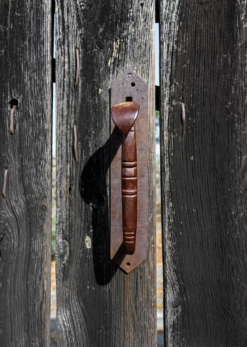 Old vintage rusty door handle on a wooden door
